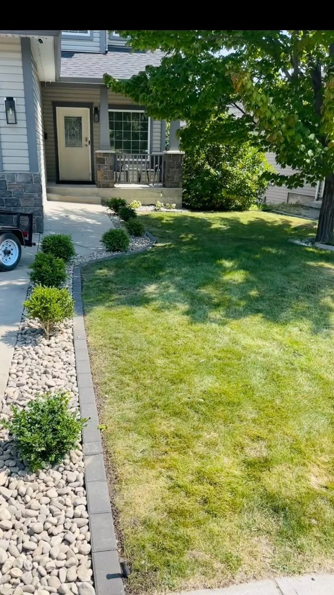 Front yard rock bed with edging and new plants